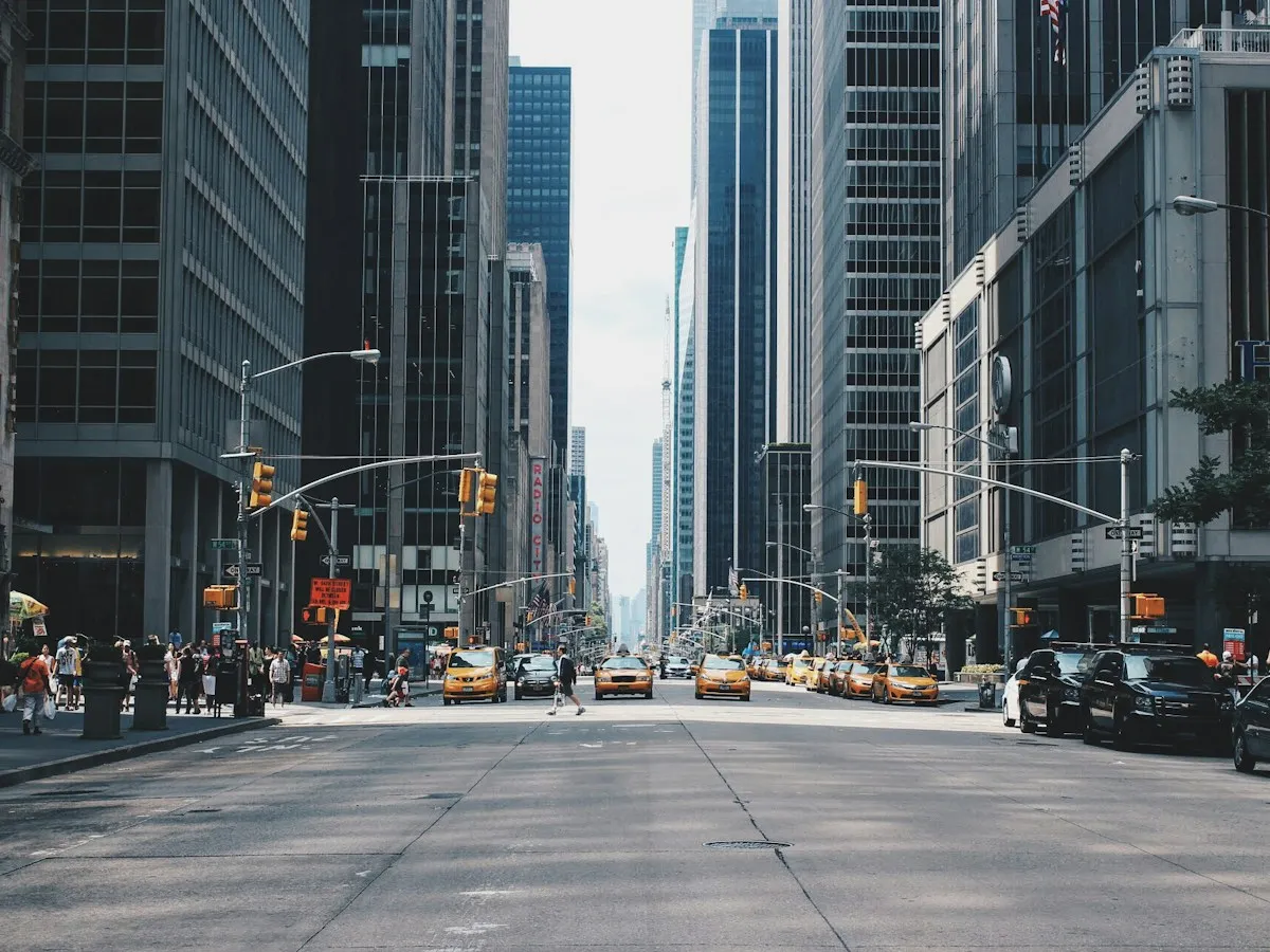 Long city avenue between tall buildings with light traffic