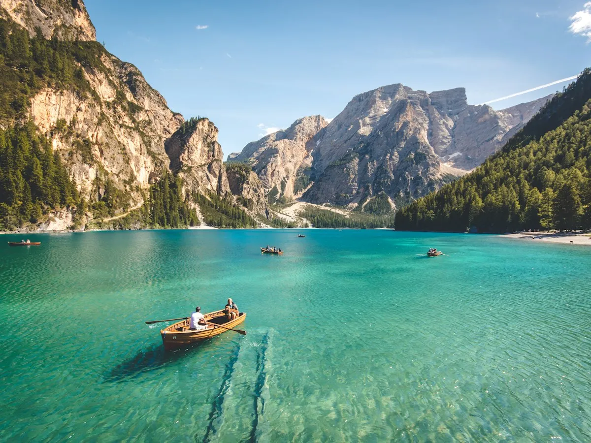 Turquoise lake with a small boat between steep mountains