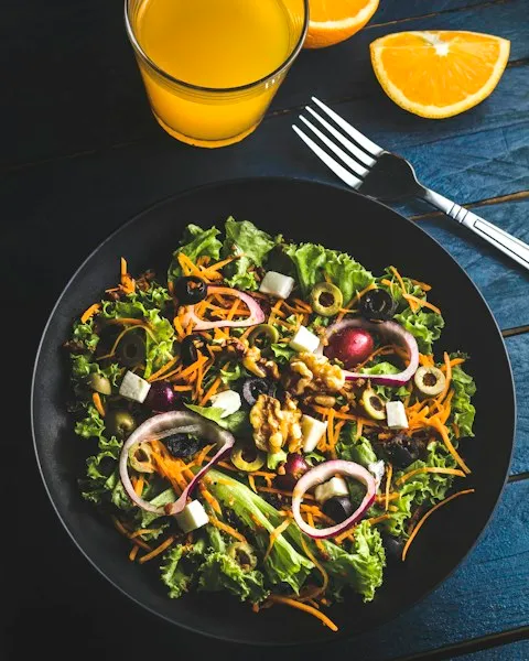 Leafy salad with carrot ribbons, feta, and red onion