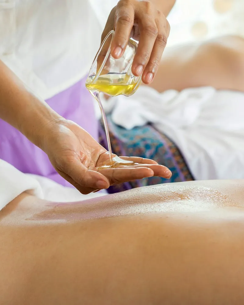 Therapist pouring massage oil during a spa treatment