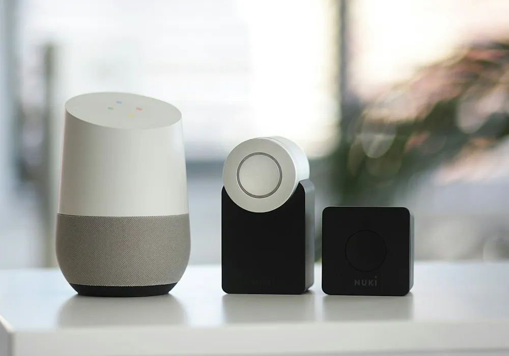 Smart speaker, smart lock, and a small hub on a white shelf