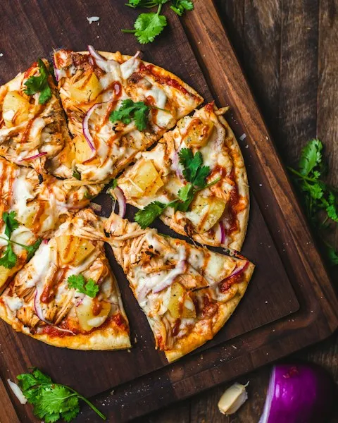 Sliced pizza with peppers and red onion on a board