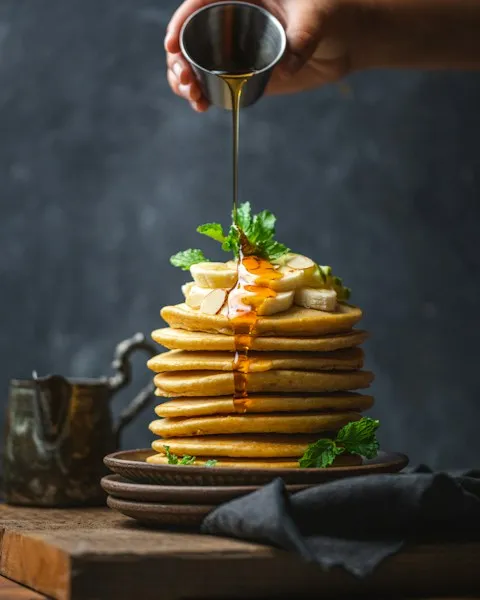 Stack of pancakes with banana and syrup