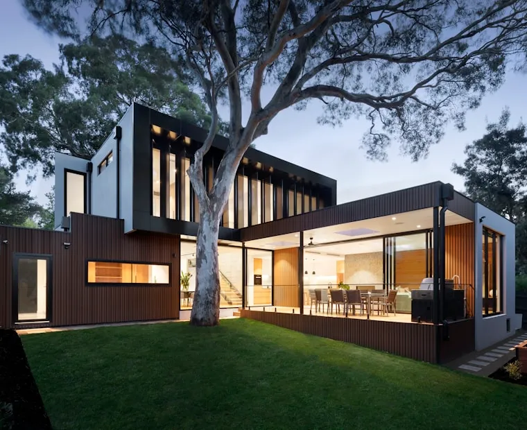 Modern residence with a clean roofline and warm exterior lighting