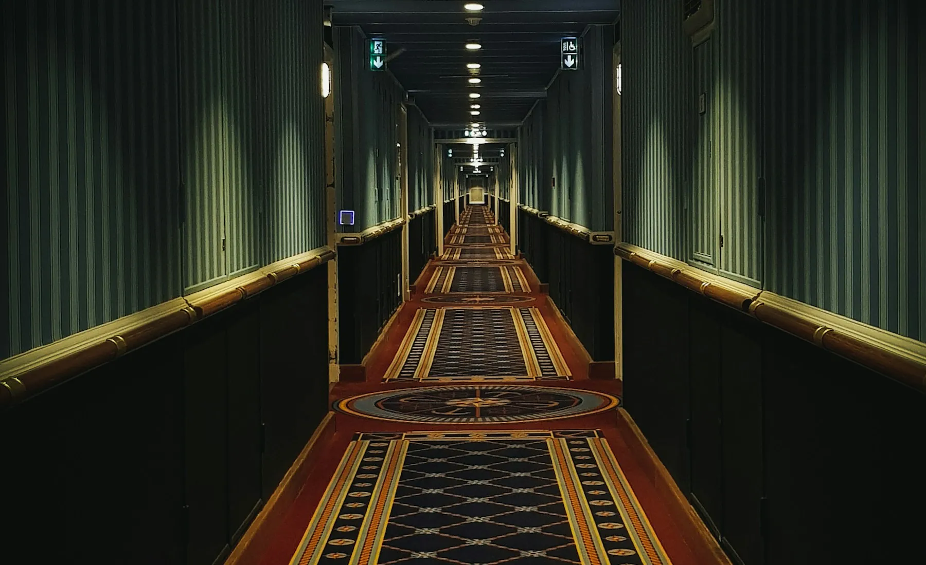 Warm, wood-lined corridor at Sable House with light beyond the guest rooms