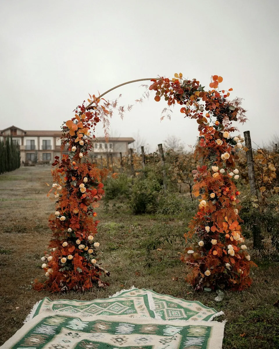 An autumn floral arch standing in a vineyard