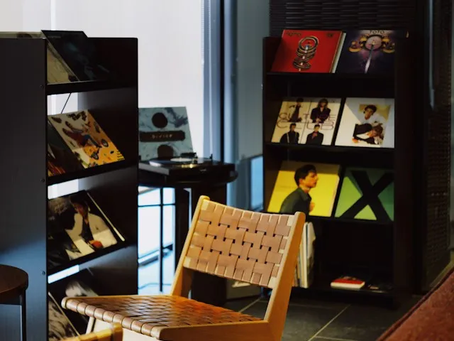 A quiet room with a woven chair and shelves of vinyl records